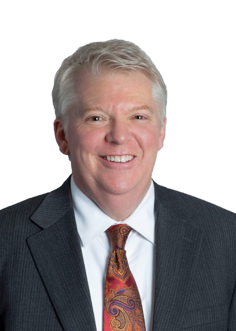 Smiling man in a suit and tie.